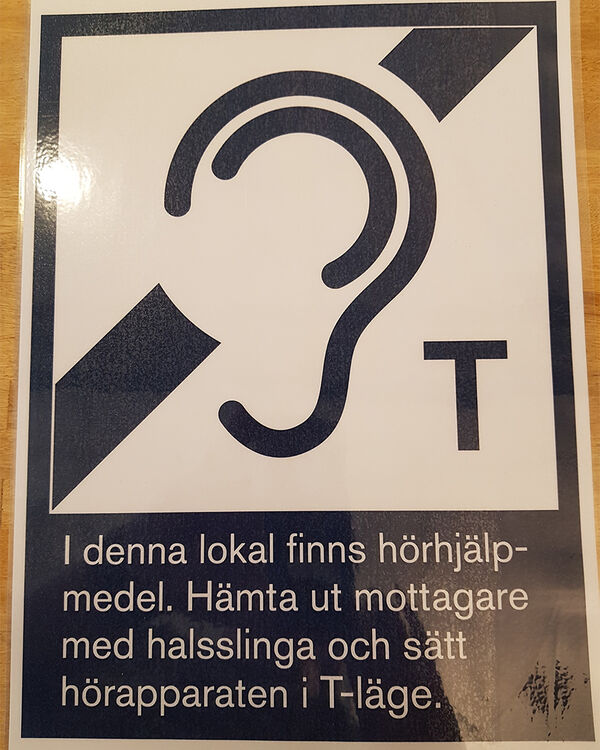 Sign for hearing aid in room. Photo. 