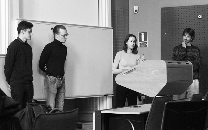 Fyra personer står i en undervisningslokal och håller en presentation.