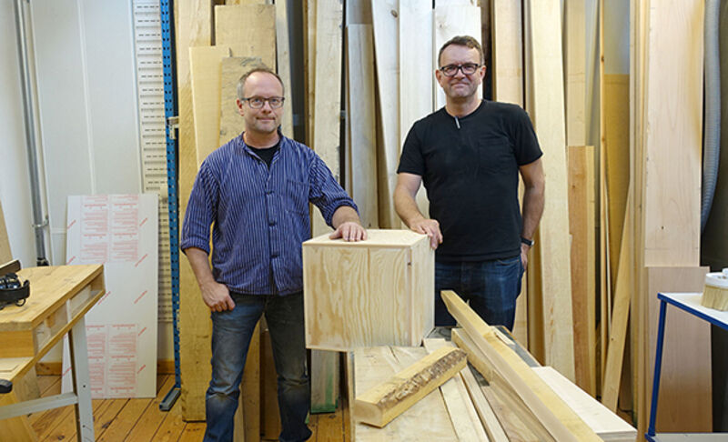 two people standing in a workshop. Photo. 