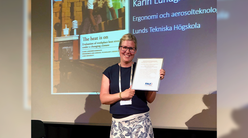 Karin Lundgren håller upp ett diplom. Foto. 