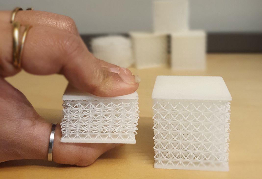 Fingrar som håller i en 3D-printad produkt. Foto.