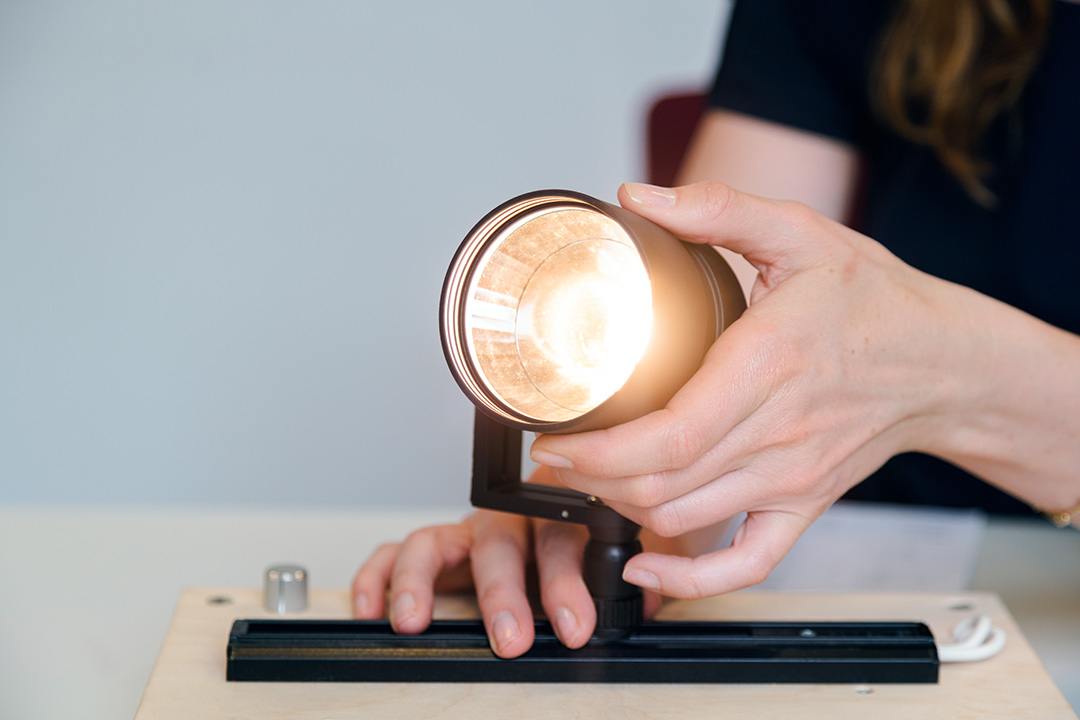 Close up of hands adjusting a spotlight.