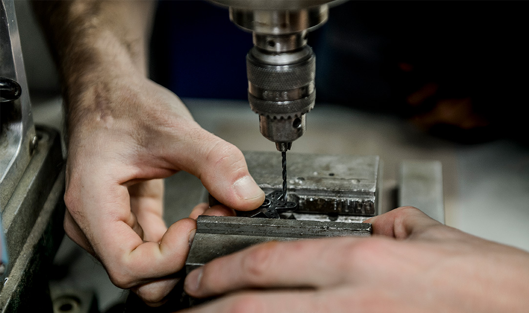 Close-up of hands working with a drill. Photo.