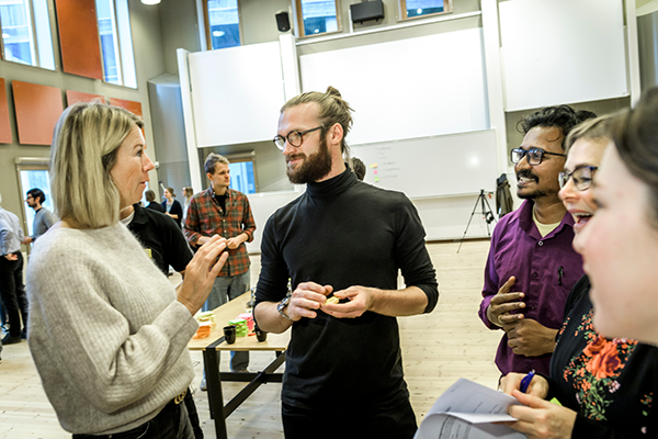 A group of people talking together in a large room.