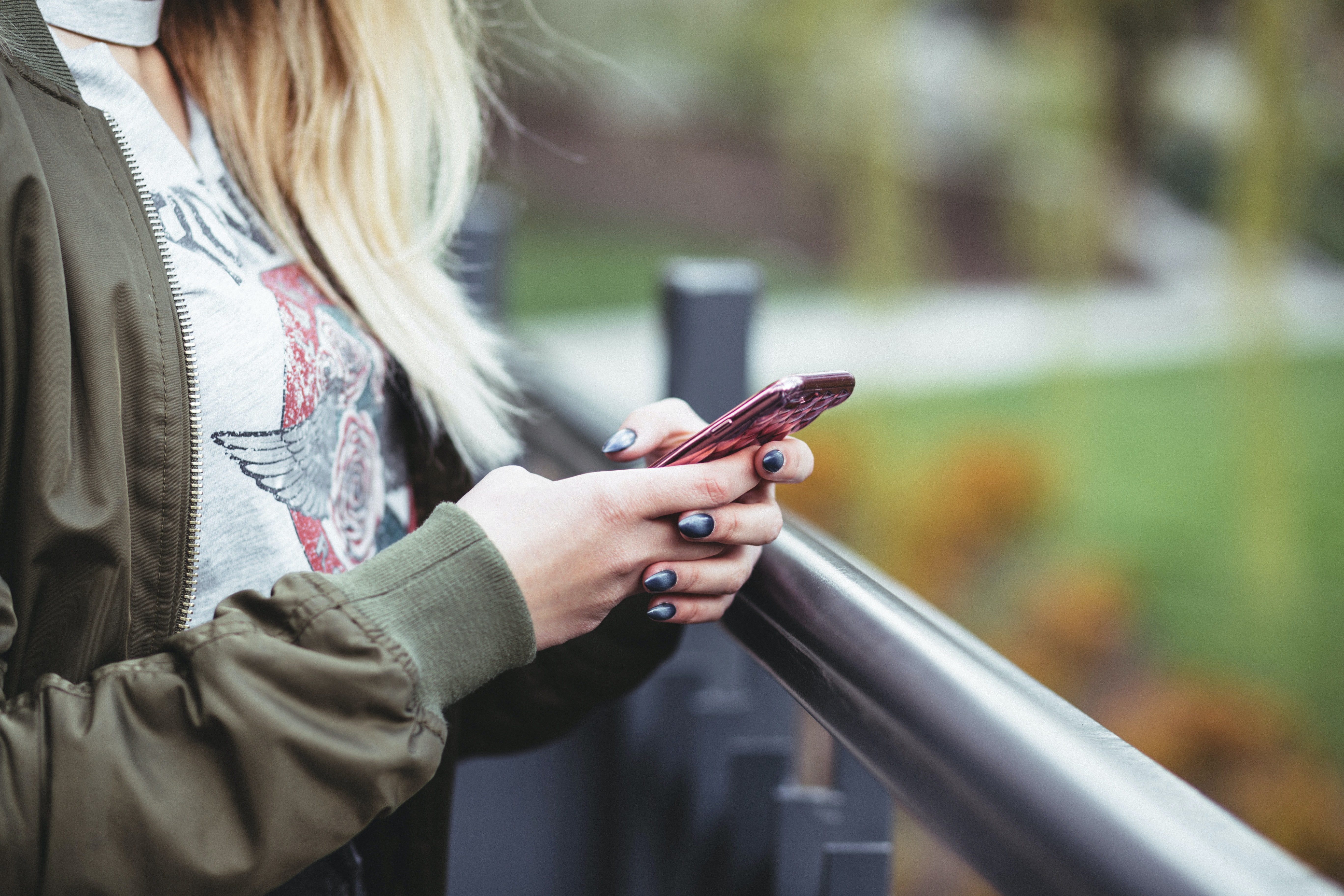 Person som håller en mobiltelefon. Foto.