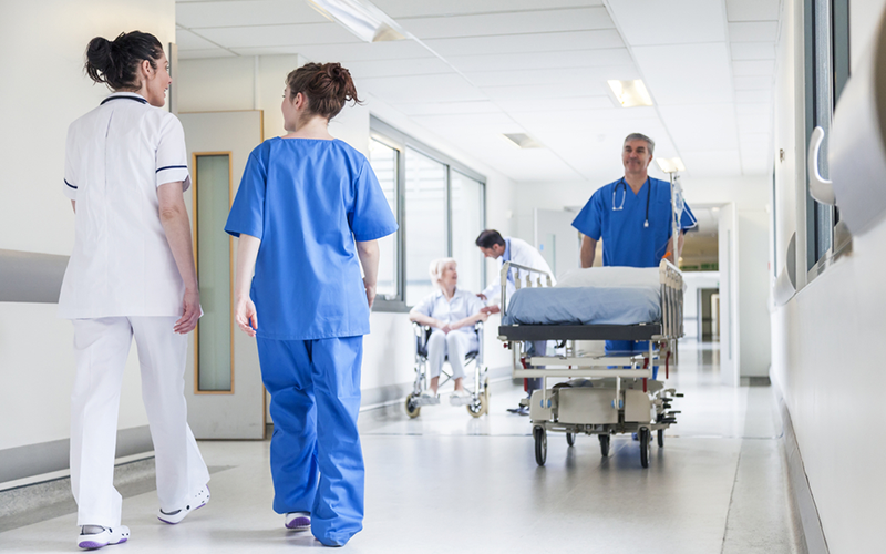Personal och patienter i en sjukhuskorridor. Foto.