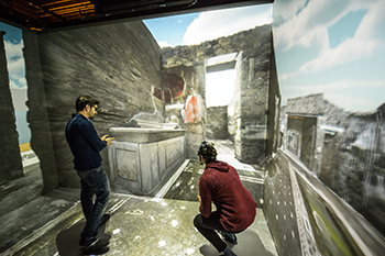 Två personer står i den virtuella modellen av Pompeji. Foto.